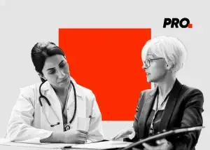 A female doctor listens attentively to a woman in business attire as they discuss documents, with a bold red square and the word PRO. in the background—perfect imagery for dynamic healthcare marketing or pharma marketing campaigns.