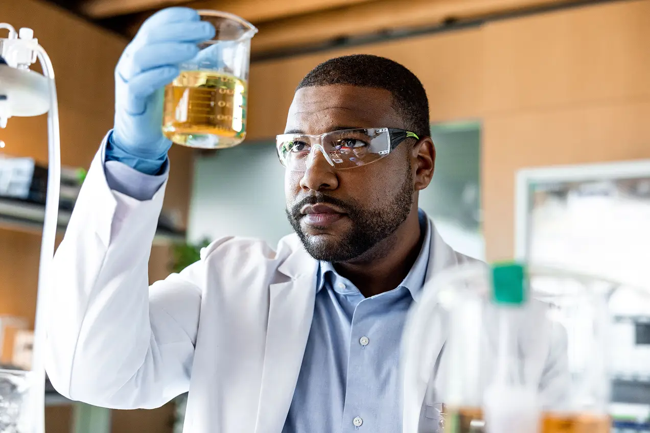 A man holding a beaker with yellow liquid, symbolizing innovation in medtech marketing and breakthrough advancements in healthcare.