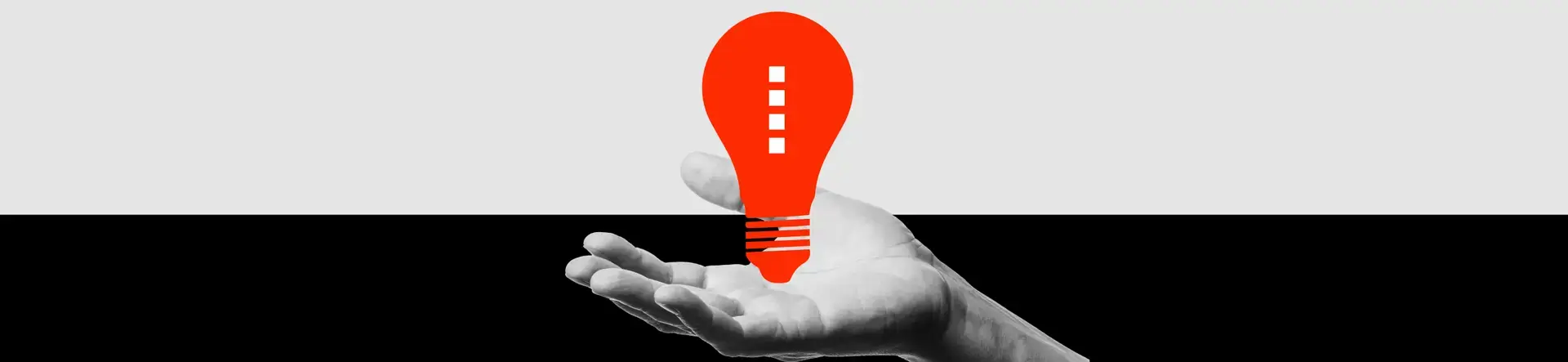 A grayscale hand is shown palm up against a divided black and white background, holding a bright red, stylized light bulb—a striking visual for pharma marketing or healthcare marketing campaigns seeking bold, innovative appeal.
